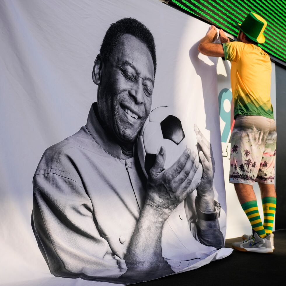 Un aficionado coloca un cartel de apoyo a Pelé en una fiesta de torcedores de Brasil previo al partido contra Corea del Sur.