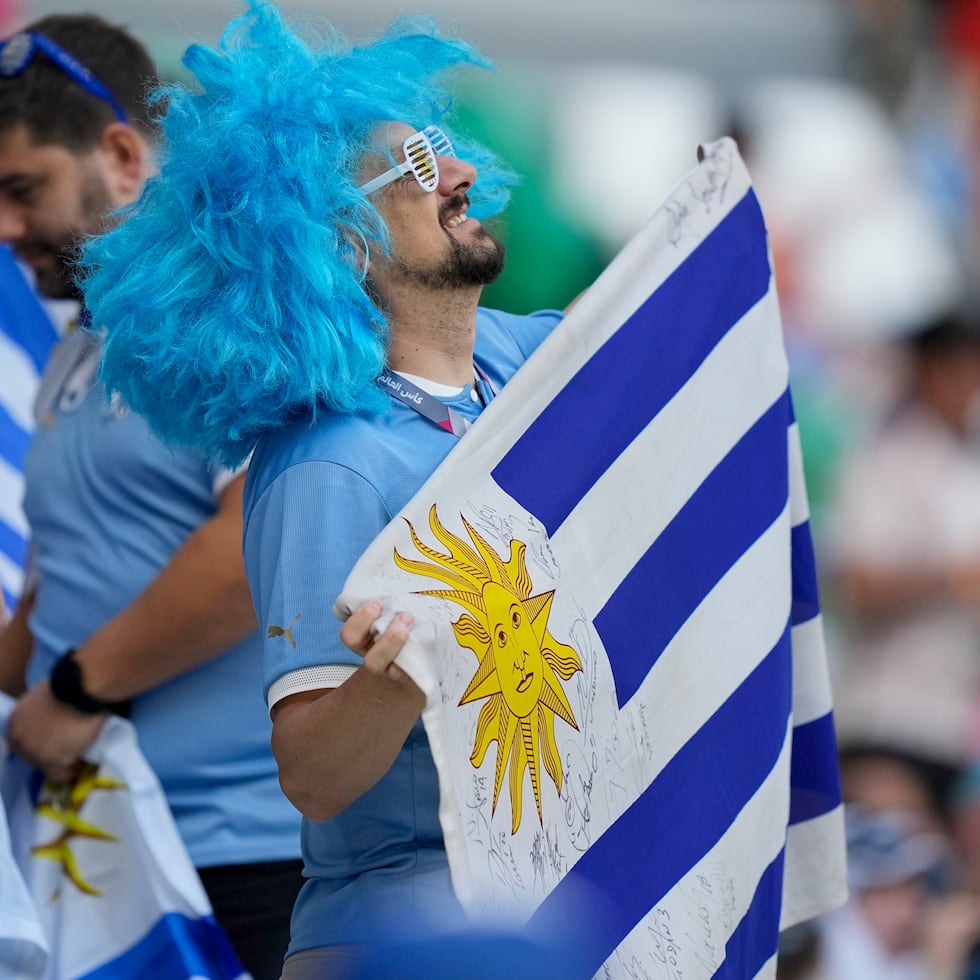 Un fanático del fútbol con la bandera de Uruguay antes del partido contra Corea del Sur en Al Rayyan, Catar.