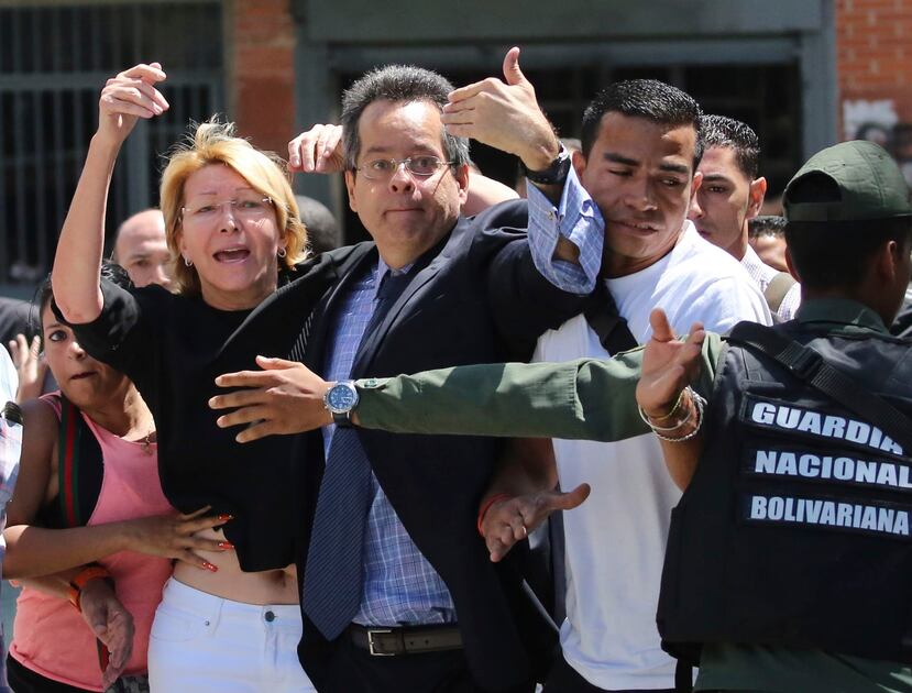 La fiscal general venezolana Luisa Ortega Díaz, a la izquierda, es rodeada por empleados de la Fiscalía General, ya que la policía no le permitió entrar a su oficina en Caracas. (AP / Wil Riera)