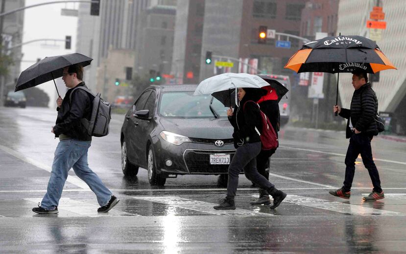 Esta foto de archivo del lunes 6 de febrero del 2017 muestra a peatones cruzando una pista bajo la lluvia en el centro de Los Ángeles. (AP/Nick Ut)
