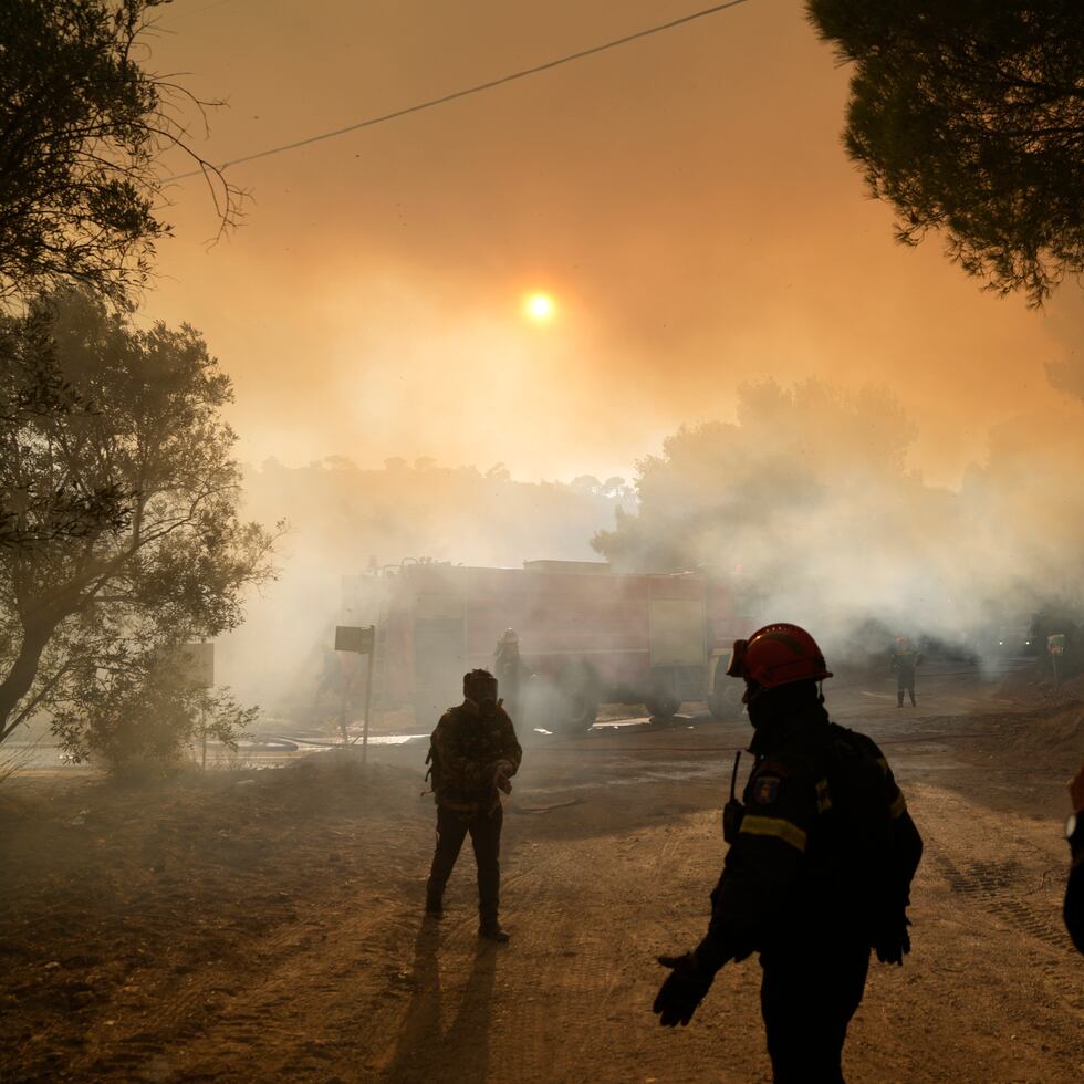Los bomberos operan durante un incendio forestal en la aldea de Siderina a unas 34 millas al sur de Atenas, Grecia.