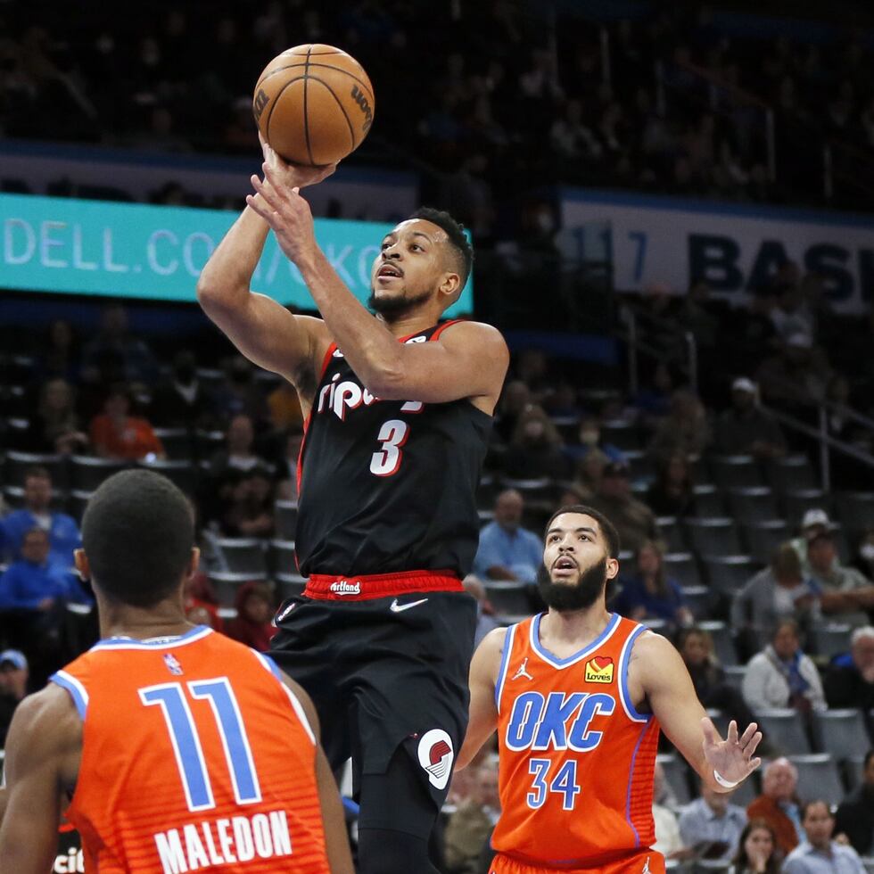 En foto del 31 de enero del 2022, el base de los Trail Blazers de Portland CJ McCollum lanza el balón sobre Theo Maledon y Kenrich Williams del Thunder de Oklahoma City.