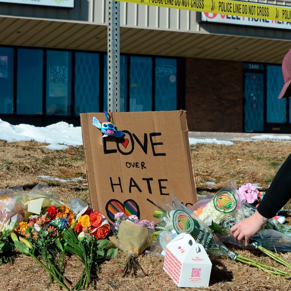 Elijah Newcomb de Colorado Springs coloca flores cerca de un club nocturno gay en Colorado Springs, Colorado, donde ocurrió una masacre el sábado por la noche.