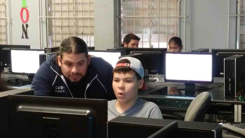 Froilan Irizarry, capitán de la brigada de Code4PuertoRico, junto a uno de los estudiantes de la Escuela Gerardo Sellés Solá que participó en la sesión tecnológica.(Suministrada)