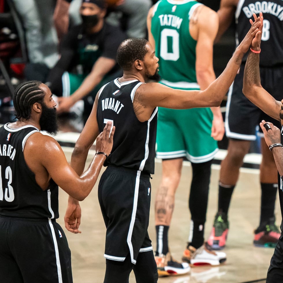 De izquierda a derecha, James Harden, Kevin Durant y Kyrie Irving, de los Nets de Brooklyn, festejan durante el primer partido de una serie de playoffs el 22 de mayo de 2021. El proyecto de juntar a los tres grandes anotadores nunca cuajó, y el equipo no estuvo ni siquiera cerca de ser contendor al título de la NBA.
