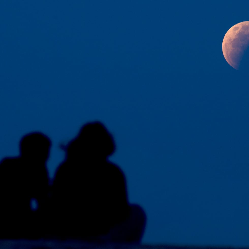 Una pareja en Sanur, Bali, localidad de Indonesia, observa el eclipse.