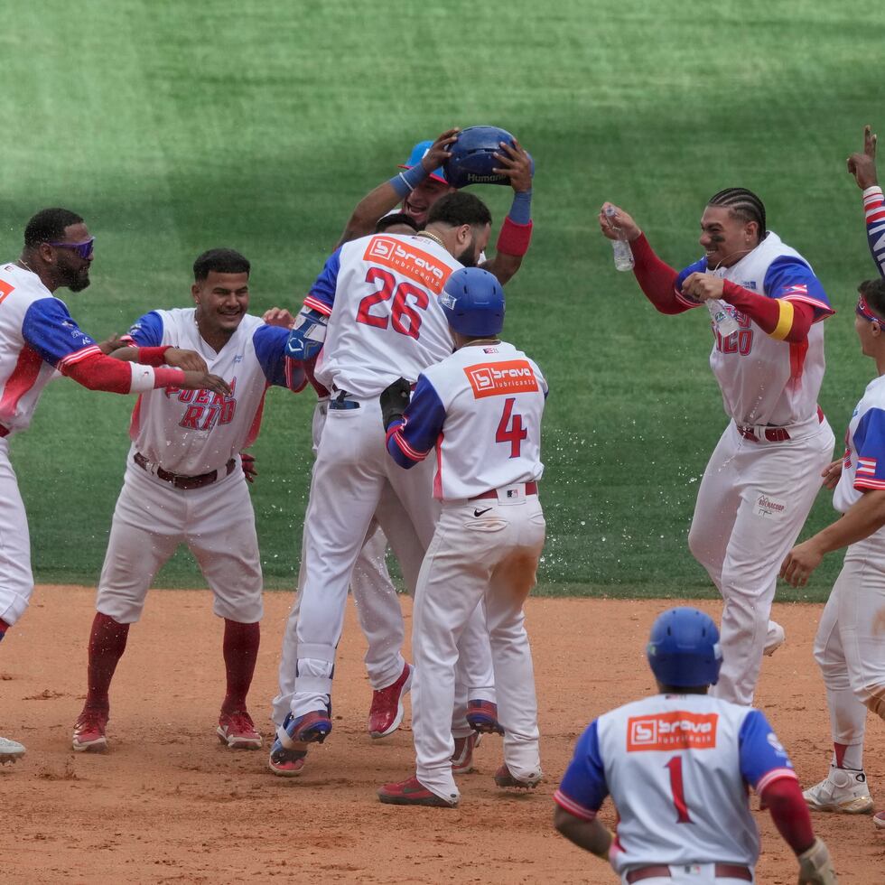 Los jugadores de los Indios de Puerto Rico celebran con Emmanuel Rivera (26), tras pegar el batazo de oro en la victoria ante Cuba.