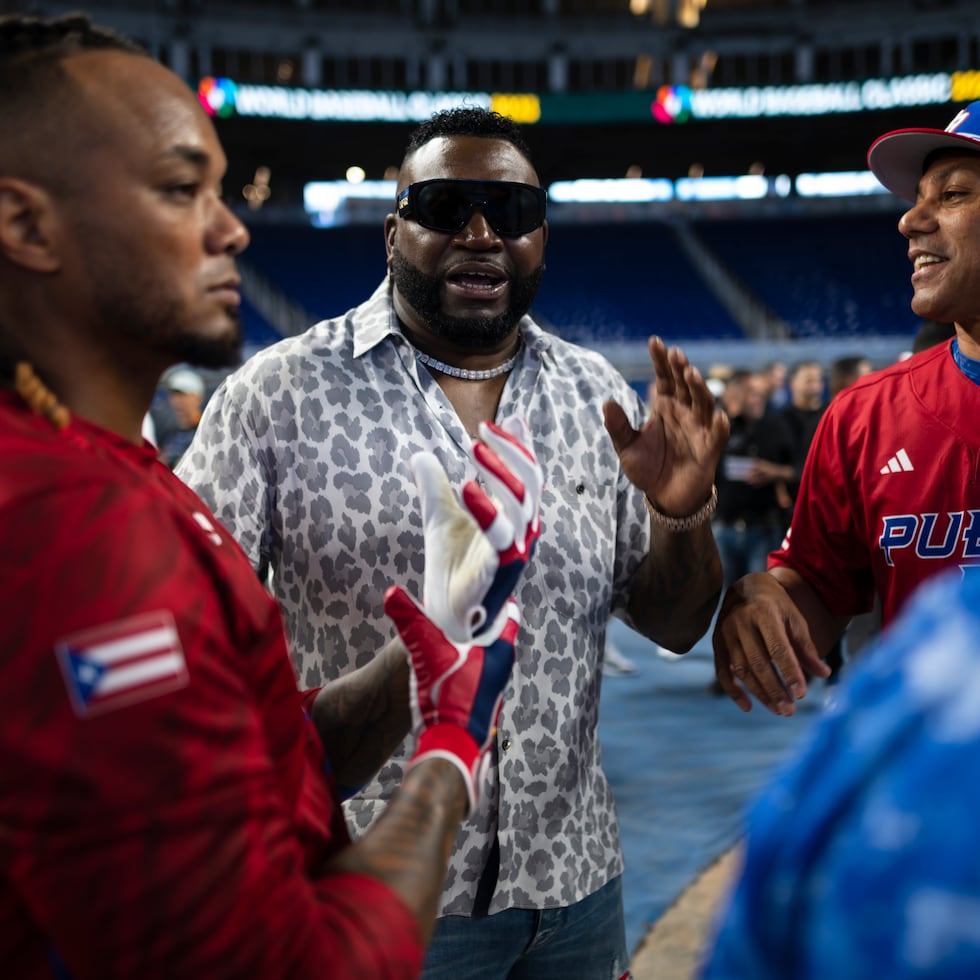 El dominicano David Ortiz, al centro, conversa con Juan "Igor" González (derecha) y Martín Maldonado (izquierda) durante la práctica de Puerto Rico en Miami.