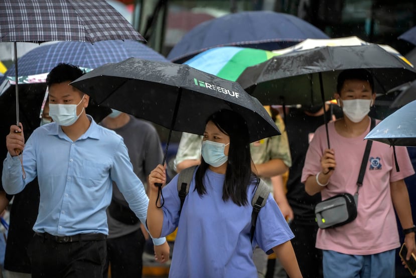 Personas con cubrebocas caminan por una calle del distrito comercial de Beijing, el 9 de agosto de 2022.