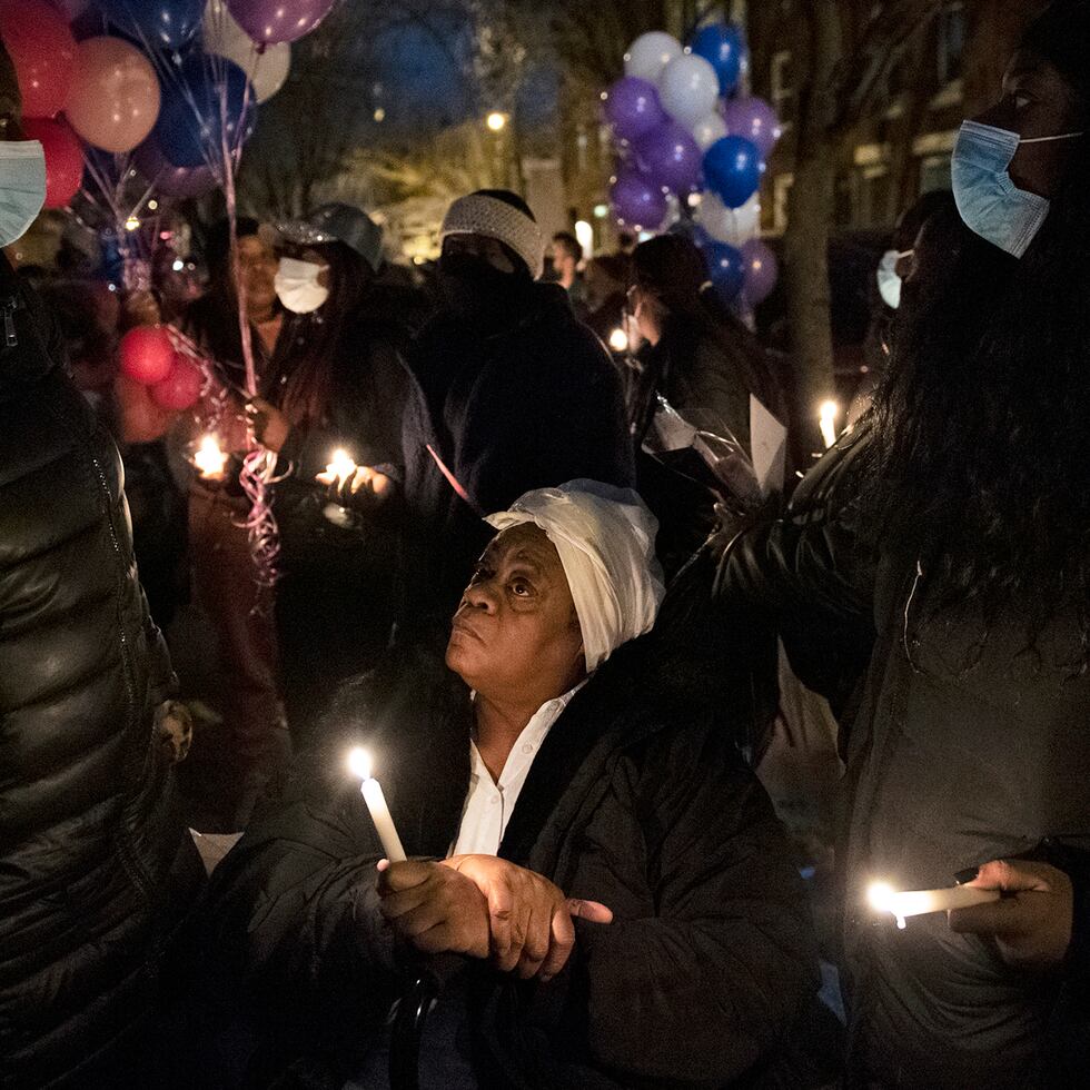 Un familiar se reúne con miembros de la comunidad para una vigilia con velas para recordar a quienes perecieron en el incendio de una casa en Filadelfia.
