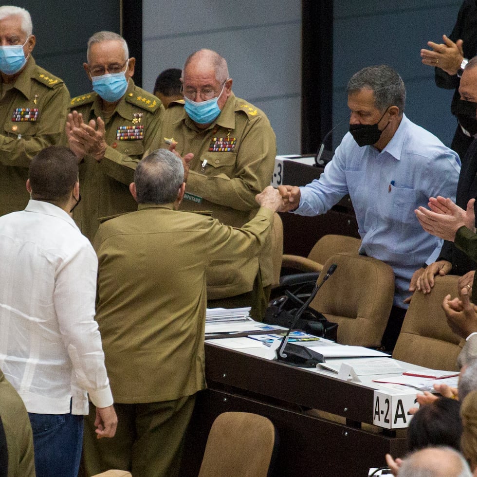 En esta foto publicada por Cubadebate, el general Luis Alberto Rodríguez López-Calleja, a la derecha, saluda al expresidente cubano Raúl Castro en la Asamblea Nacional en La Habana, Cuba, el 21 de diciembre de 2021. López-Calleja, uno de los asesores más confiables de Castro y jefe de la división comercial militar del país, murió el 1 de julio de 2022 a los 62 años. (Irene Pérez/Cubadebate via AP)