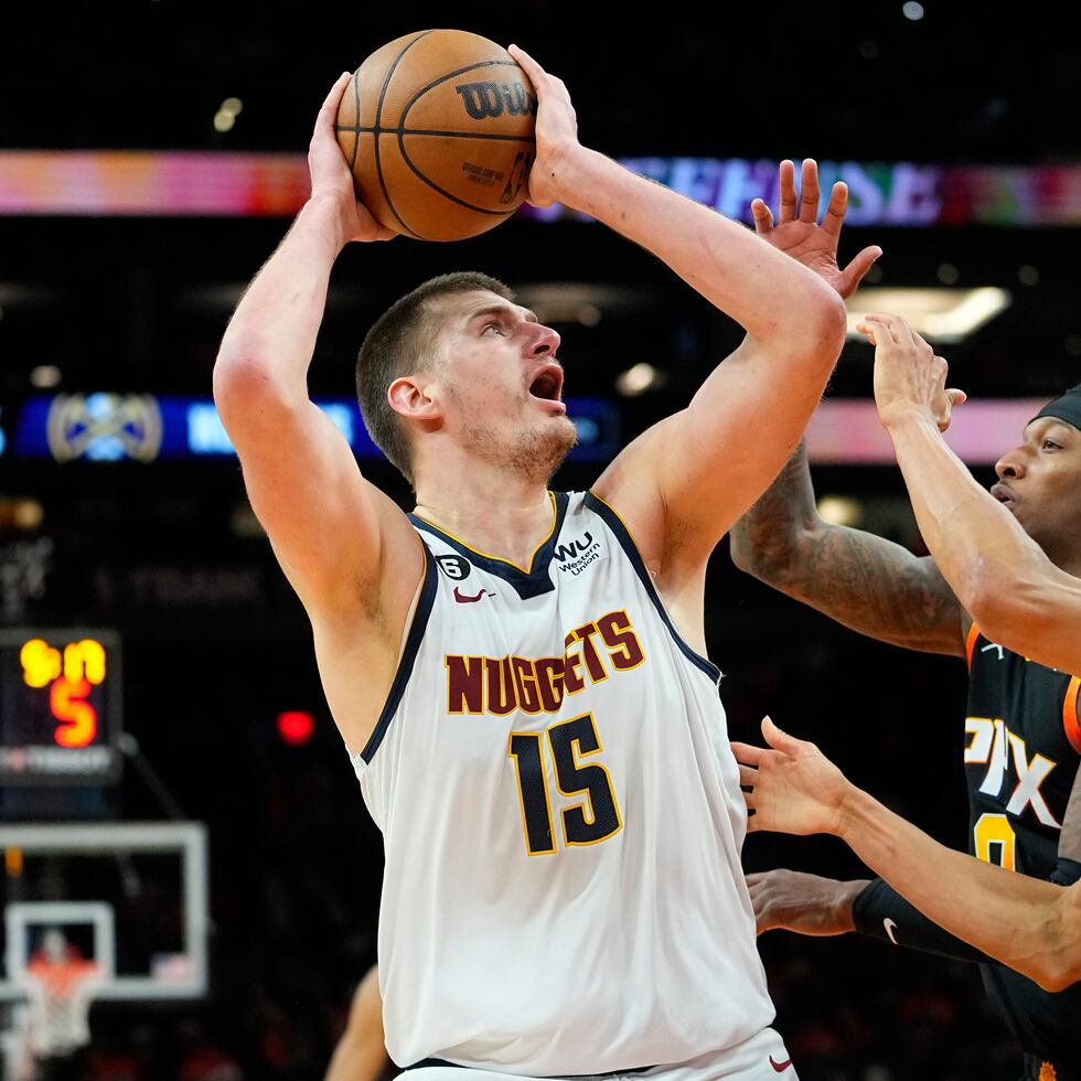 El serbio Nikola Jokic dispara por los Nuggets de Denver frente a Landry Shamet (derecha) y Torrey Craig, de los Suns de Phoenix, en el sexto duelo de la semifinal de la Conferencia Oeste.