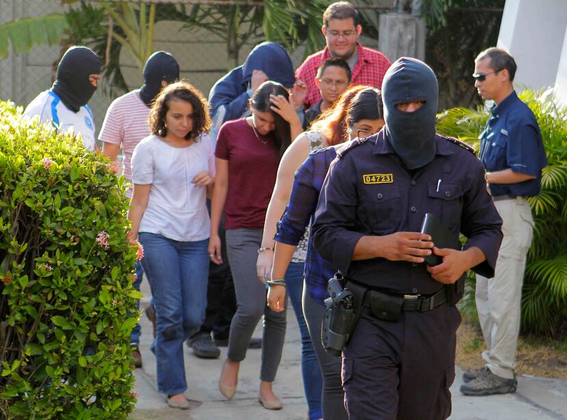 Agentes de la Policía Nacional Civil (PNC) de El Salvador custodian a empleados al allanar las instalaciones de la oficina del bufete panameño Mossack-Fonseca en San Salvador. (EFE / Oscar Rivera)