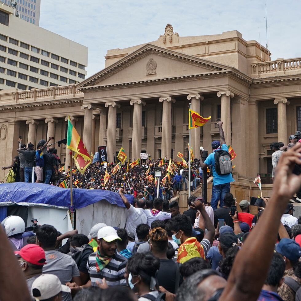 Manifestantes, muchos con banderas de Sri Lanka, se reúnen en torno a la oficina del presidente en Colombo, Sri Lanka, el sábado 9 de julio de 2022. (AP Foto/Thilina Kaluthotage)