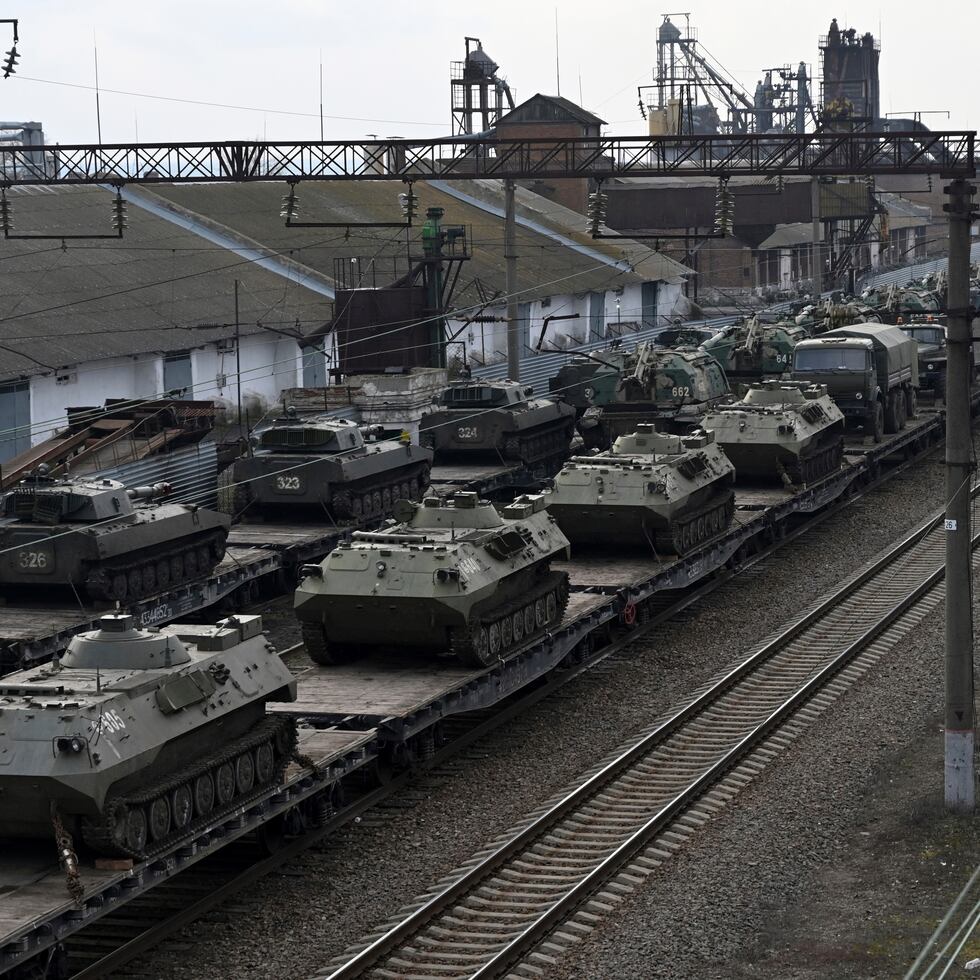 Vehículos blindados rusos son cargados a plataformas del tren en una estación de una región cerca de la frontera entre Rusia y Ucrania, en la región de Rostov del Don, en Rusia, el miércoles 23 de febrero de 2022. (AP Foto)