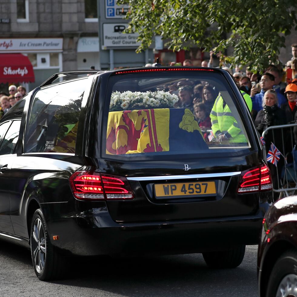 Ciudadanos se alinean en las calles de Ballater, Escocia, mientras el coche fúnebre que lleva el ataúd de la reina Elizabeth II pasa en su viaje a Edimburgo desde Balmoral en Escocia.