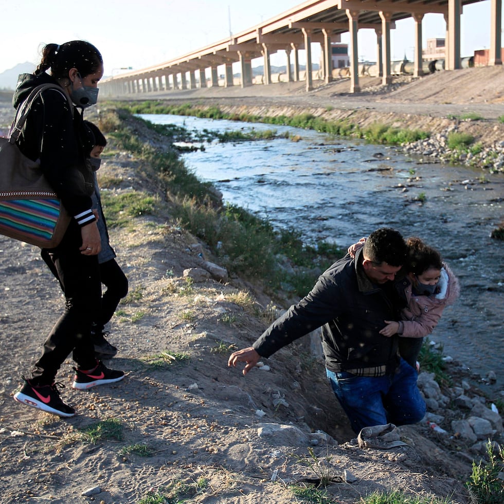 Fotografía del 5 de marzo de 2021 donde se observa a una familia que intenta cruzar el Río Bravo hacia Estado Unidos, por la frontera de Ciudad Juárez, Chihuahua (México).