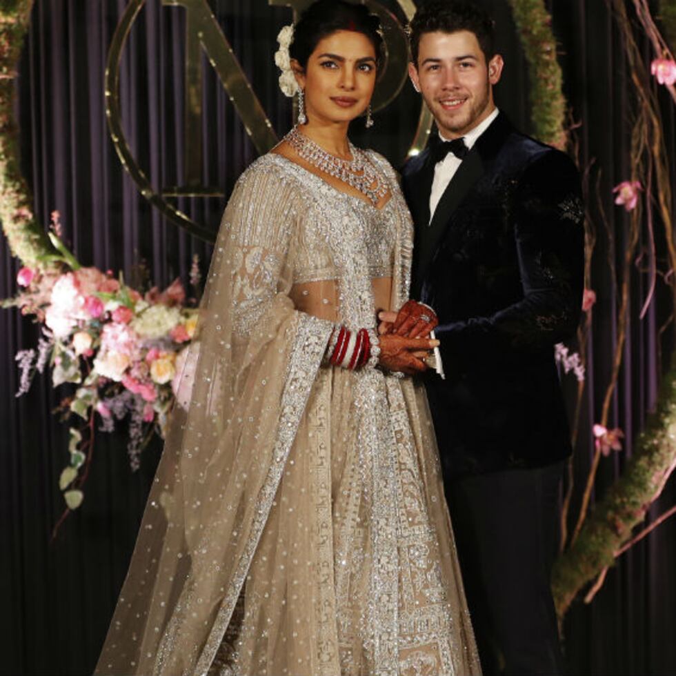 La actriz Priyanka Chopra y el cantante Nick Jonas posan para la prensa durante la recepción de su boda hindú. (Foto: AP)