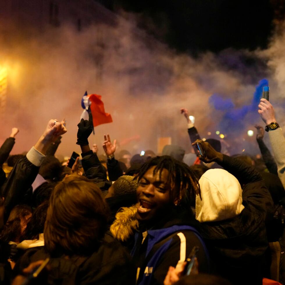 Seguidores de Francia reaccionan junto al Arco del Triunfo en la avenida de los Campos Elíseos al término del partido de semifinales del Mundial de fútbol entre Francia y Marruecos, en París, el miércoles 14 de diciembre de 2022. (AP Foto)