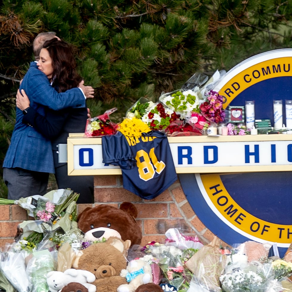 Gov. Gretchen Whitmer embraces Oakland County Executive Dave Coulter as the two leave flowers and pay their respects Thursday morning, Dec. 2, 2021 at Oxford High School in Oxford, Mich. A 15-year-old boy has been denied bail and moved to jail after being charged in the Michigan school shooting that killed four students and injured others.(Jake May/The Flint Journal via AP)