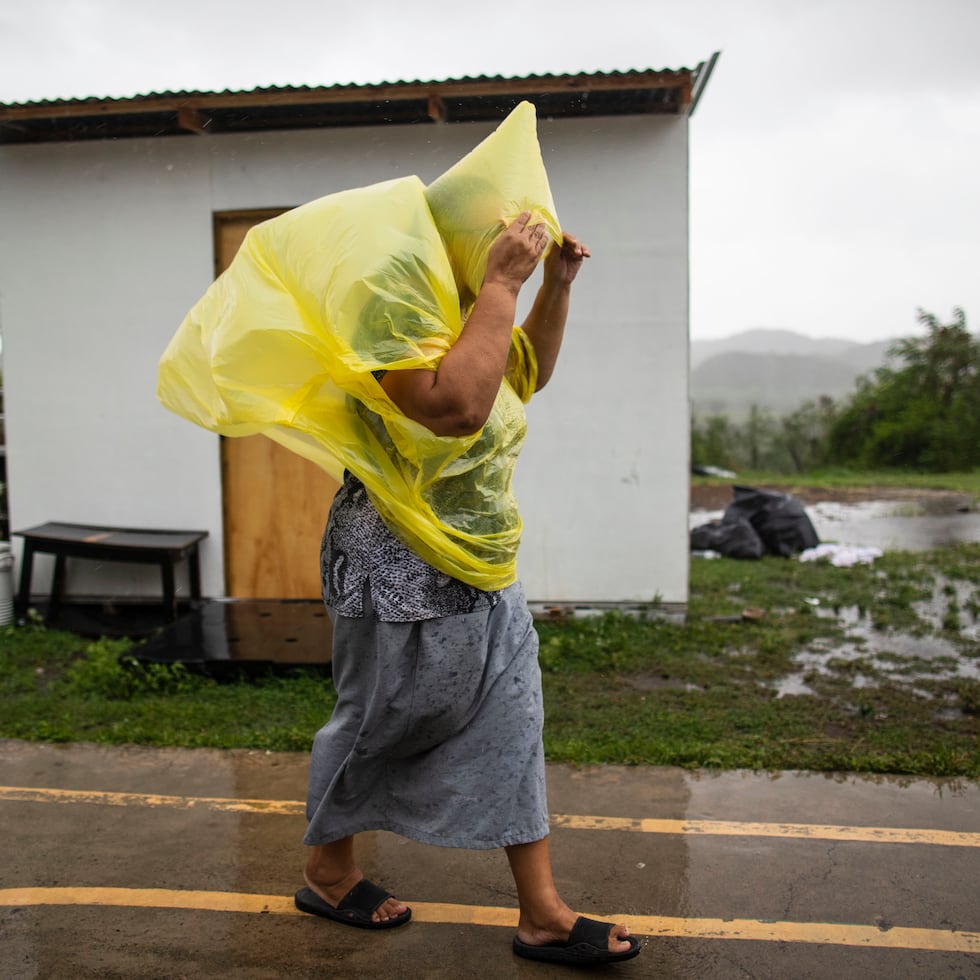 Gunica, Puerto Rico, Julio 30 , 2020 - MCD - FOTOS para ilustrar una historia sobre el paso de la tormenta tropical Isaias por el sur de Puerto Rico . La foto se realiz en el da 136 (JUEVES) del toque de queda total como medida de minimizar la propagacin del Coronavirus (COVID-19). Anglica Rivera estaba alojada en una de varias estructuras de vivienda temporal en un campamento en el sector Siberia, barrio Encenada - Rivera vive en la casucha de madera junto a su esposo Santos Garca, su hija (postrada en cama) y sus nietos. EN LA FOTO Rivera sali a la intemperie con capa de lluvia para llegar a otro de los mdulos donde se hospeda su hermana.
FOTO POR:  tonito.zayas@gfrmedia.com
Ramon "Tonito" Zayas / GFR Media