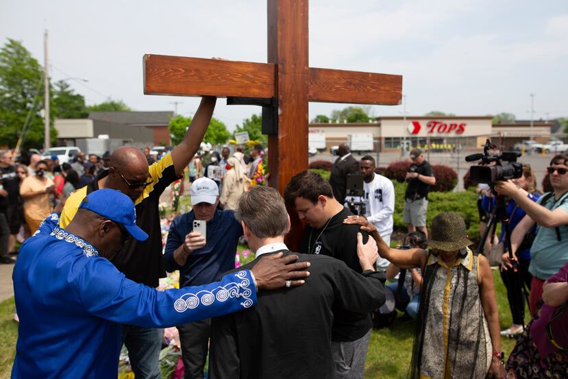 Un grupo reza en el sitio de un monumento en memoria de las víctimas del tiroteo en el supermercado de Buffalo, Nueva York.