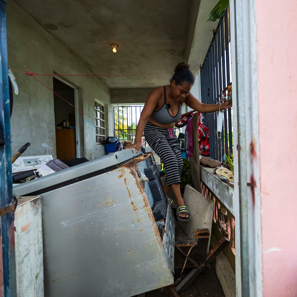 Canovanas , Puerto Rico, Septiembre 20 , 2022 - MCD -  FOTOS para ilustrar una historia sobre los estragos del paso del huracán Fiona en  Canóvanas  . EN LA FOTO Belkis Germán (vecina de la comunidad Valle Hill en Canóvanas) mostró las condiciones que quedó su hogar luego del paso del huracán - muebles , ropa , enceres (nevera) , etc , arruinados por la acumulación de agua - Germán sale de su casa escalando por encima de cosas que se acumularon en la entrada de su casa .   
FOTO POR:  tonito.zayas@gfrmedia.com
Ramon " Tonito " Zayas / GFR Media
