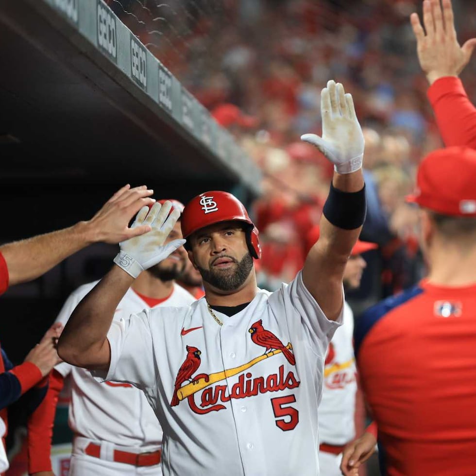 Albert Pujols celebra con sus compañeros en el dugout luego de su jonrón 701.