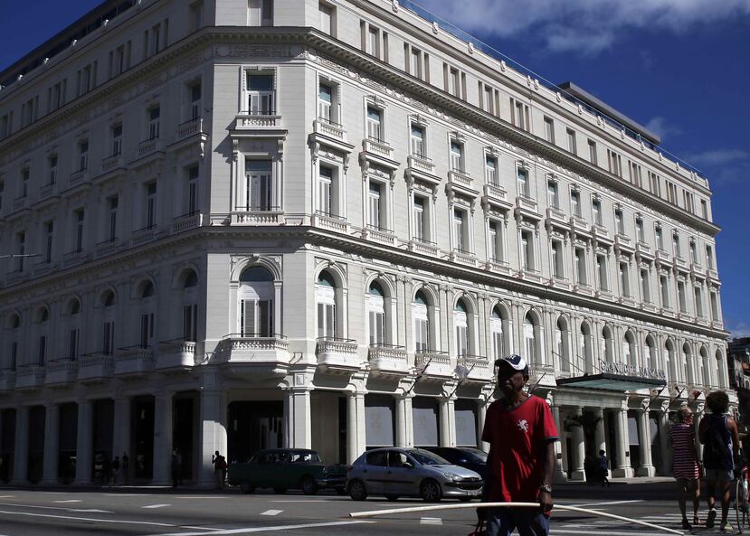 Varias personas caminan hoy, miércoles, junto al Gran Hotel Manzana Kempinski, en La Habana, Cuba. (EFE)