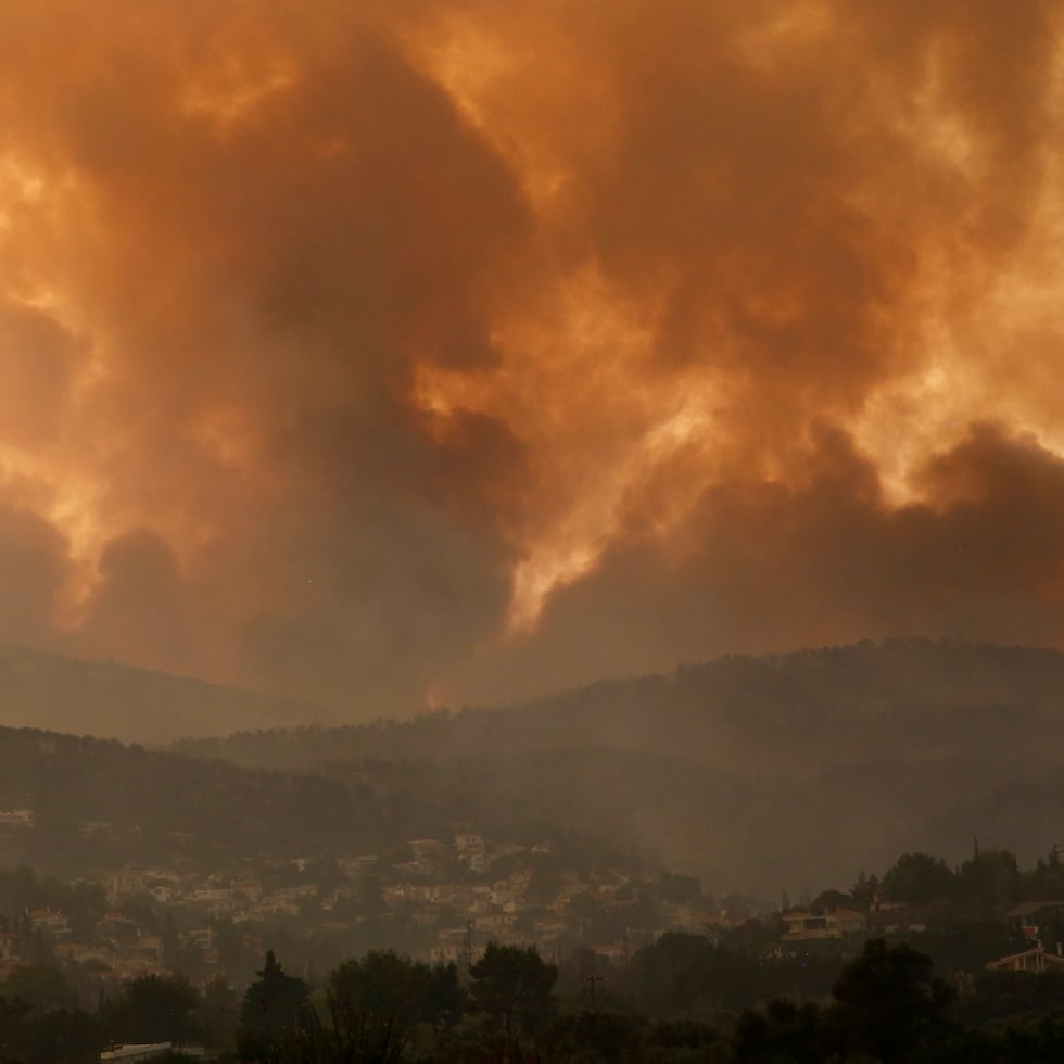 En esta imagen de archivo del 6 de agosto de 2021, el humo se extiende sobre el monte Parnitha durante un incendio forestal en el poblado de Ippokratios Politia, en Grecia.
