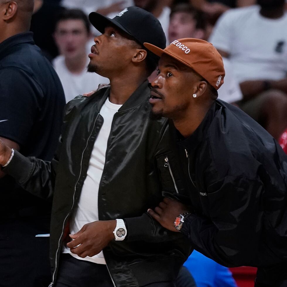 Kyle Lowry (izquierda) y Jimmy Buler, del Heat de Miami, ven desde la banca la segunda mitad del quinto partido de la serie contra los Hawks de Atlanta.