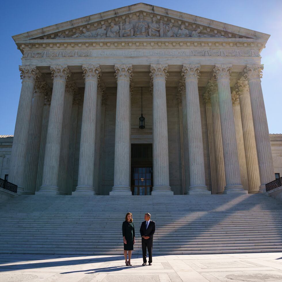 La jueza adjunta Amy Coney Barrett (izquierda) es acompañada a la tradicional ceremonia de investidura por el presidente del Tribunal Supremo, John Roberts, en la sede de la Corte Suprema en Washington, el viernes 1 de octubre de 2021. (AP foto/J. Scott Applewhite)