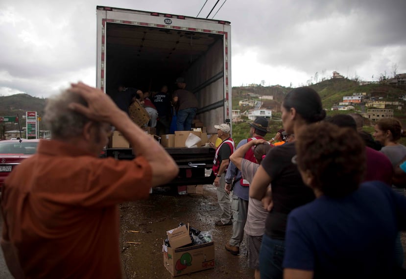Vecinos del barrio Perchas, de Morovis, hacen fila para recibir alimentos por parte de personal de la Cruz Roja