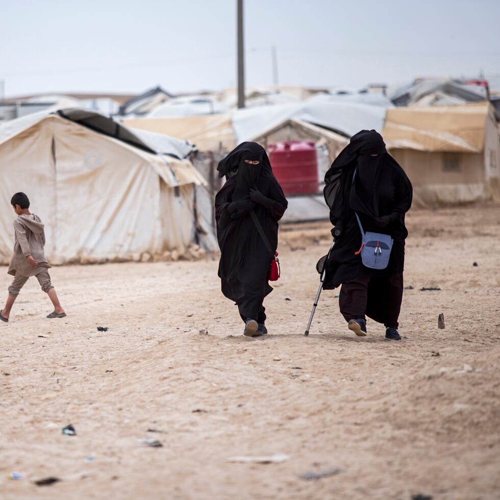 Mujeres caminan por el campamento de al-Hol, Siria, que alberga a unos 60,000 refugiados, incluyendo mujeres y niños vinculados con el grupo extremista Estado Islámico.