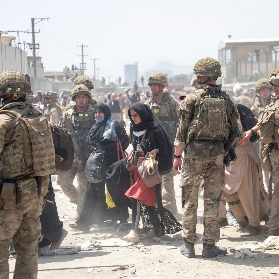 In this photo provided by the Ministry of Defence, members of the British and US military engage in the evacuation of people out of Kabul, Afghanistan on Friday, Aug. 20, 2021. (Ministry of Defence via AP)