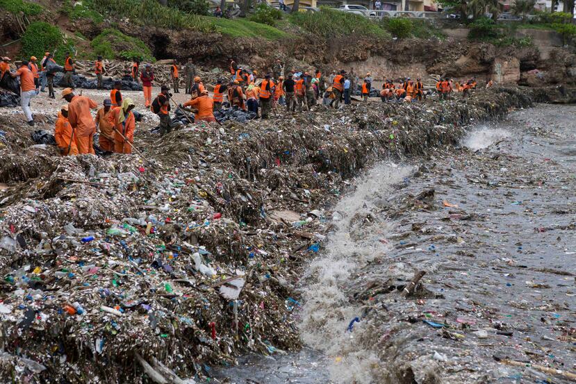 Brigadas del Ministerio de Obras Públicas y Comunicaciones trabajan en la limpieza de basura en la costa de Santo Domingo. (EFE)