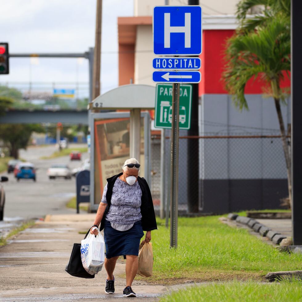 El salario digno o justo se define como el salario necesario para cubrir los gastos familiares básicos, más todos los impuestos relevantes. En la foto, una mujer camina por la avenida Barbosa luego de hacer compras en un supermercado.