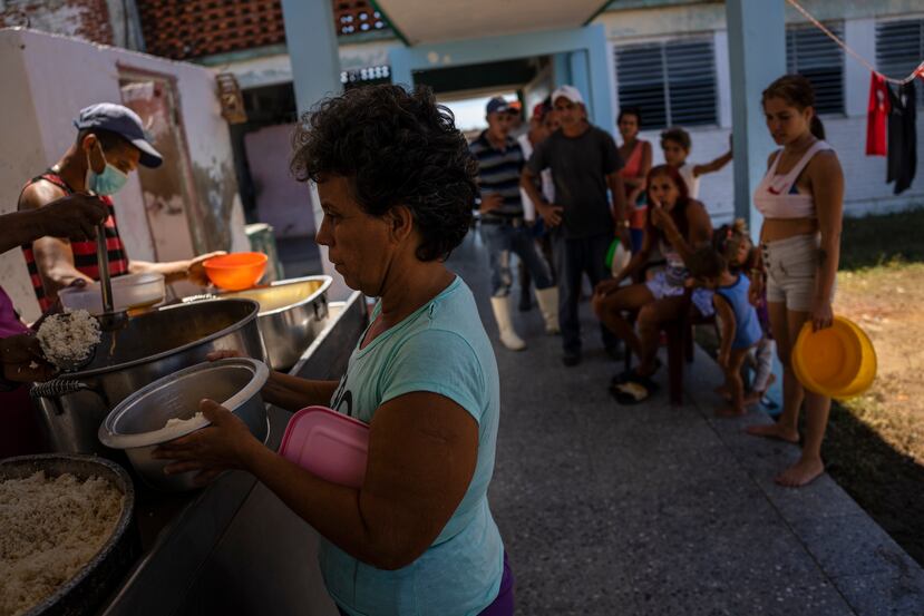 Cubanos buscan una comida caliente en una escuela que sirve como refugio en La Coloma.