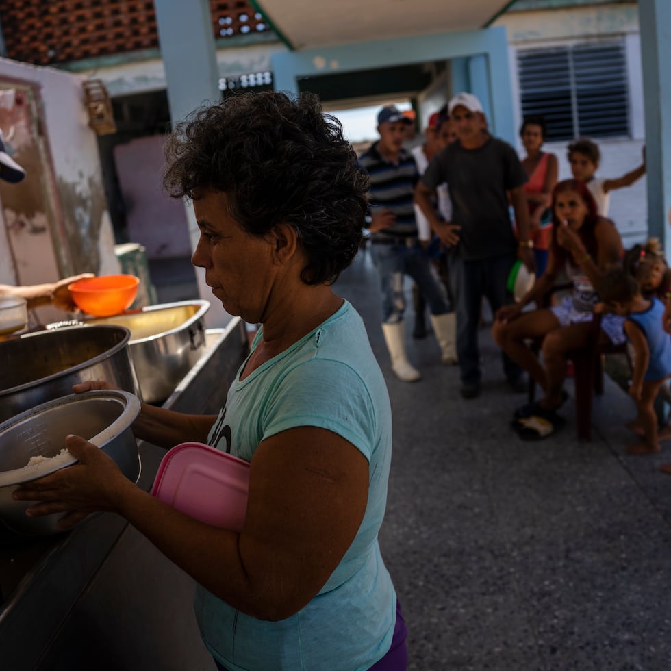 Cubanos buscan una comida caliente en una escuela que sirve como refugio en La Coloma.
