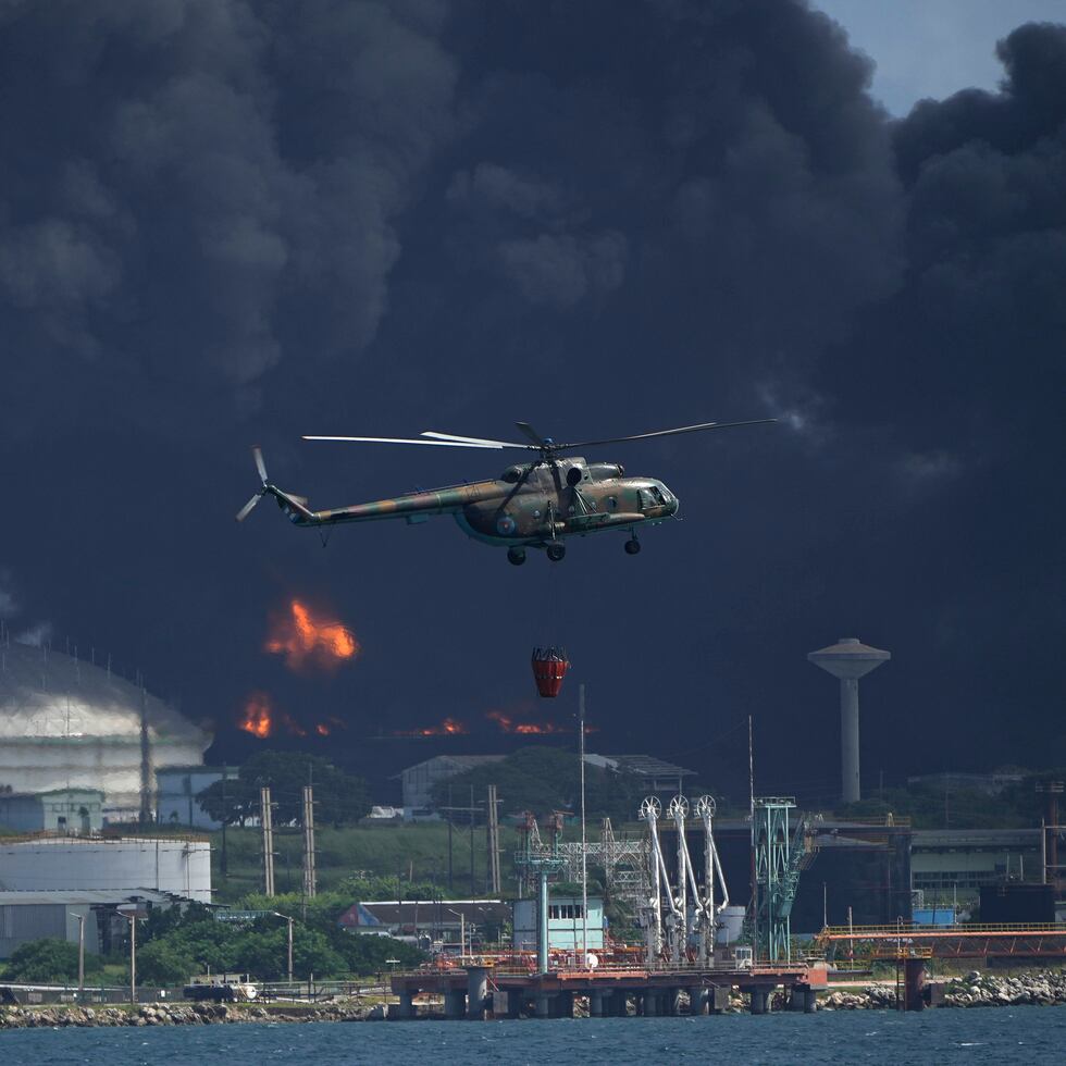 Una enorme columna de humo se eleva desde la base de superpetroleros de Matanzas, mientras los bomberos trabajan para sofocar un incendio que comenzó durante una tormenta eléctrica la noche anterior, en Matazanas, Cuba.