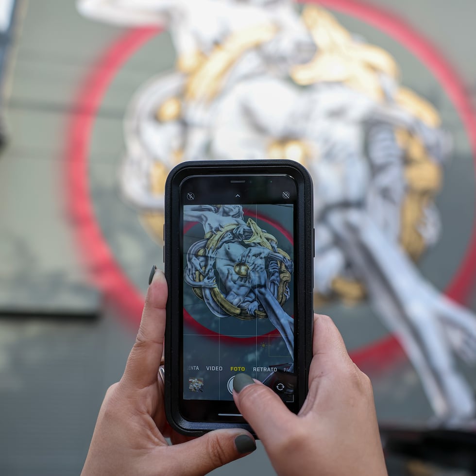 Una persona toma una foto del mural de Rafa Algarín durante "Santurce es Ley".
