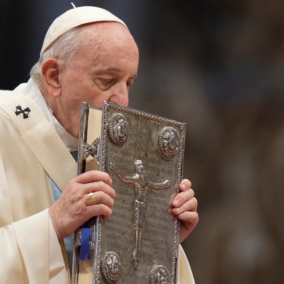 El papa Francisco besa el Libro Sagrado durante la misa de Año Nuevo, en la Basílica de San Pedro, en el Vaticano, el 1 de enero de 2022. (AP Foto/Andrew Medichini)