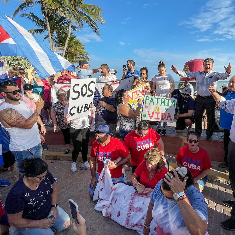 El pastor Arturo Ramirez, derecha, ora durante una protesta el martes 13 de julio de 2021, en Southernmost Point de Key West, Florida. (Rob O'Neal/The Key West Citizen vía AP)