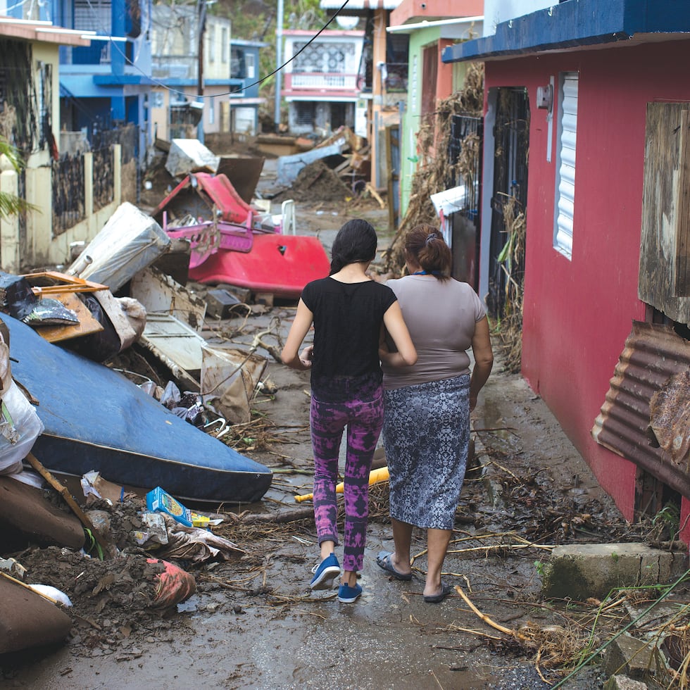 Algunas comunidades sufrieron el impacto del huracán María de manera particular. En esta foto de octubre de 2017, dos mujeres caminan entre los escombros en el sector Chichamba de Yauco.