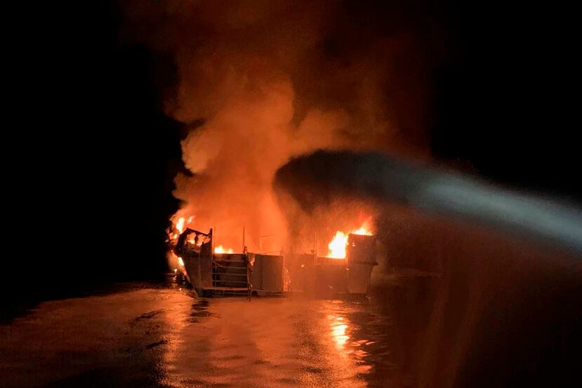 Los bomberos intentando apagar el incendio en el barco esta mañana. (AP)