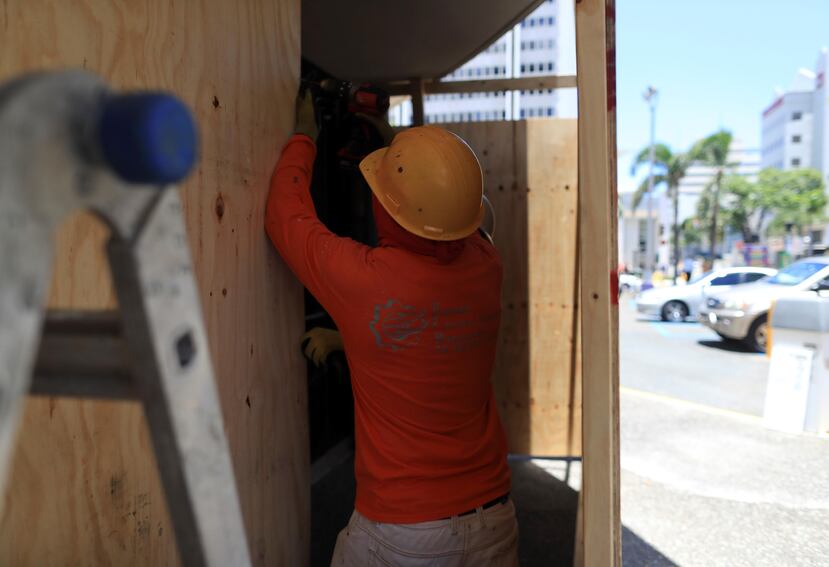 Constructores trabajaban  ayer colocando paneles en edificios de la avenida Ponce de León, en preparación a las manifestaciones de hoy.