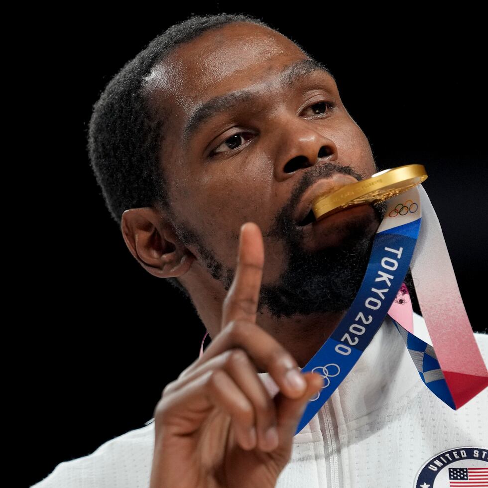 Kevin Durant posa para una foto mordiendo la medalla de oro de Estados Unidos en baloncesto ganada en Tokio.