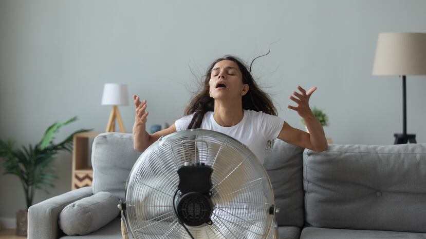 Una mujer se ubica frente a un abanico para contener la sensación de calor.