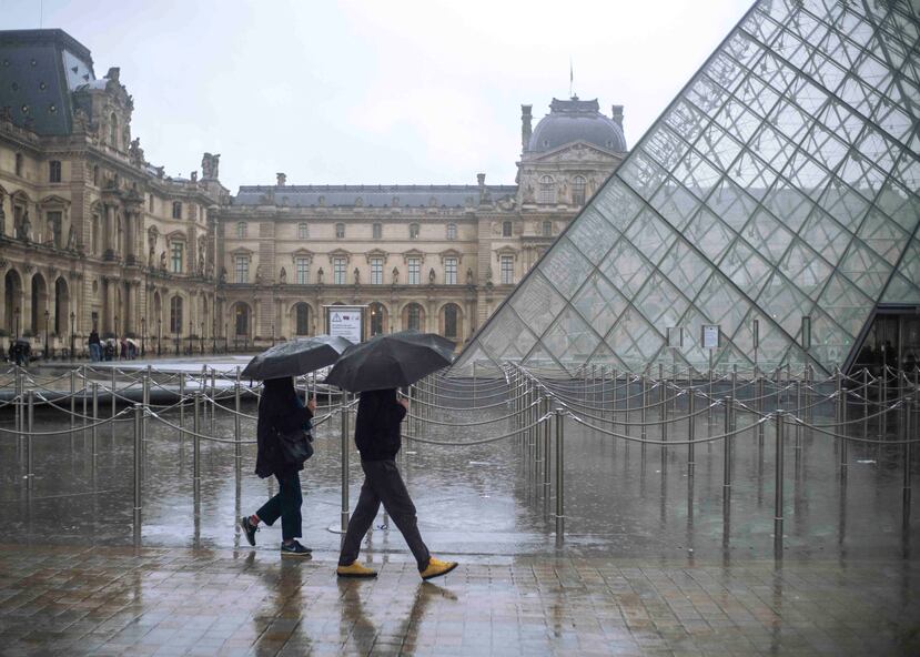 Un grupo de turistas esperan para entrar al Museo Louvre. (AP)