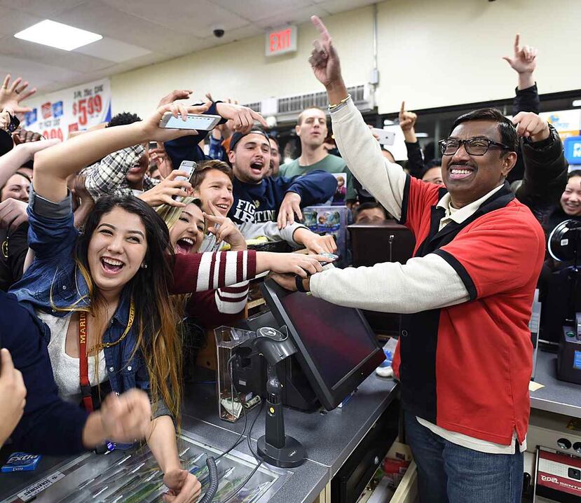 Dependiente de la tienda que vendió uno de los boletos ganadores en California celebra con el público que se dio cita al local. (AP)